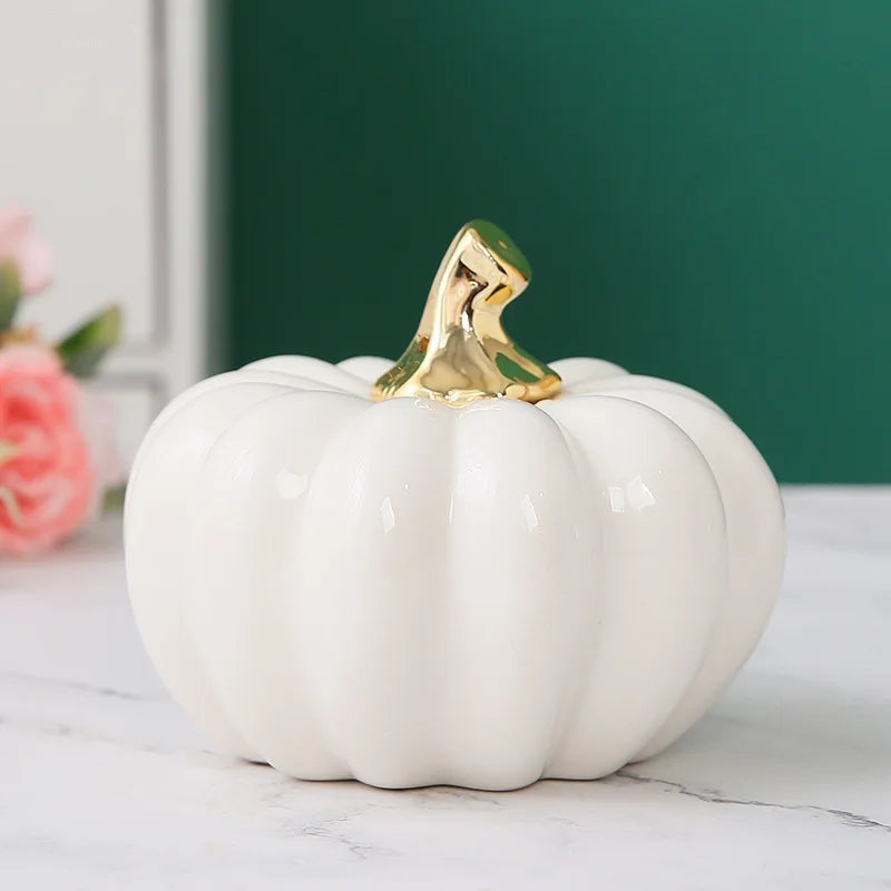 White ceramic pumpkin with a gold top on a marble surface